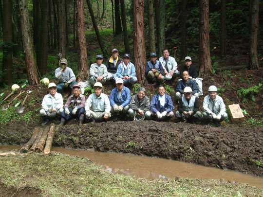 池の掘削、丸太橋の架け替えなど、作業が無事に終了し、集合写真に納まる隊員たちの画像